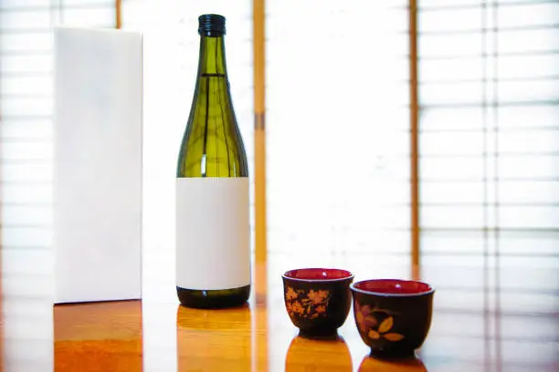 Japan blank Sake bottle and box with lackered cups in front of paper doors