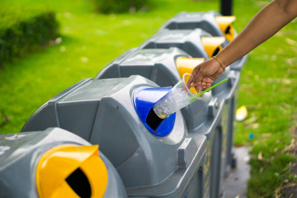 istock Young girl hand dropping plastic bottle into recycle bin and there are waste separation bin for different kind of garbage to safe environment. pollution or waste management business concept 828635130