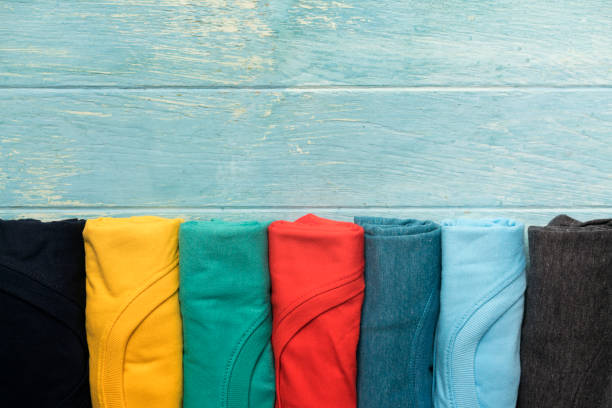 close up of rolled colorful clothes on table background