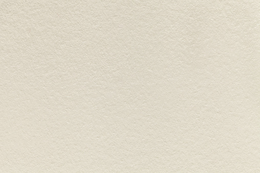 Texture of old light beige paper background, closeup. Structure of dense sand cardboard.