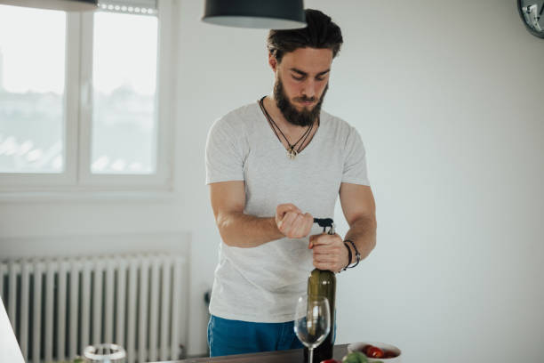istock Man opening bottle of wine, close-up 828645322
