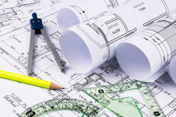 istock Architectural blueprints and blueprint rolls and a drawing instruments on the worktable. Drawing compass, plans. Civil Engineering, Construction background. 828646282