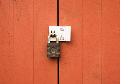 a metal padlock protecting locking two wooden doors outside; UK