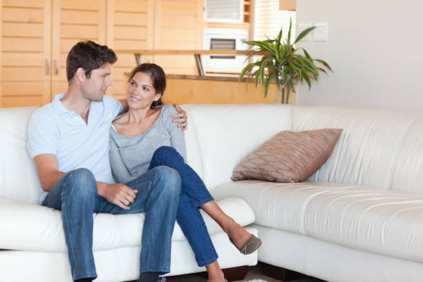 istock Smiling couple sitting on a couch 828668706