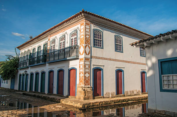 visão geral de paralelepípedos alagado rua com casas antigas, o pôr do sol em paraty. - cobblestone rio de janeiro brazil parade - fotografias e filmes do acervo