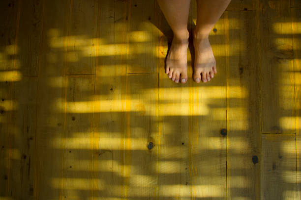 Close up bare foot in the morning with floral shadows,  relaxing.  Lying and enjoying rest.