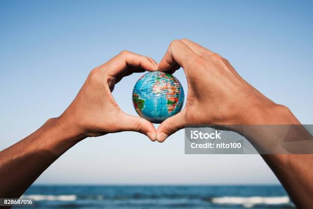Young Man With A World Globe In His Hands Stock Photo - Download Image Now - Globe - Navigational Equipment, Travel, Sustainable Lifestyle
