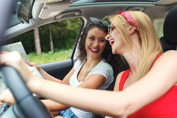 istock Two laughing young girlfriends traveling in a car. 828689688