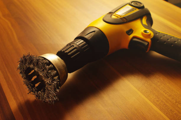 Screwdriver with iron brush on a wooden table.