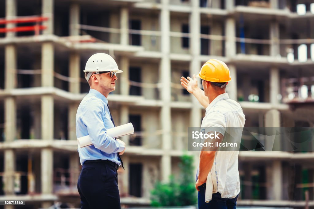 Architect and builder discussing at construction site Architect and builder discussing at construction site. Personal Organizer Stock Photo