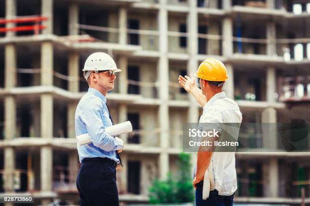 Architect And Builder Discussing At Construction Site Stock Photo - Download Image Now