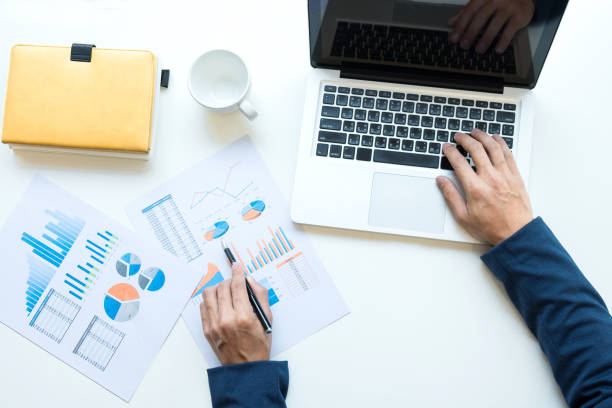 istock Business man working at office with laptop and documents on his desk. Analyze plans, papers, hands keyboard, business concept 828719296