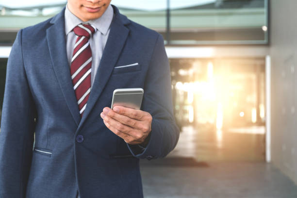 istock A handsome young businessman holding while using his phone and standing on the street 828719346