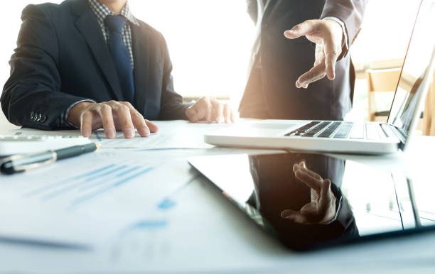 istock Coworking process, Business team two colleagues discussing new plan financial graph data on office table with laptop and digital tablet 828719388