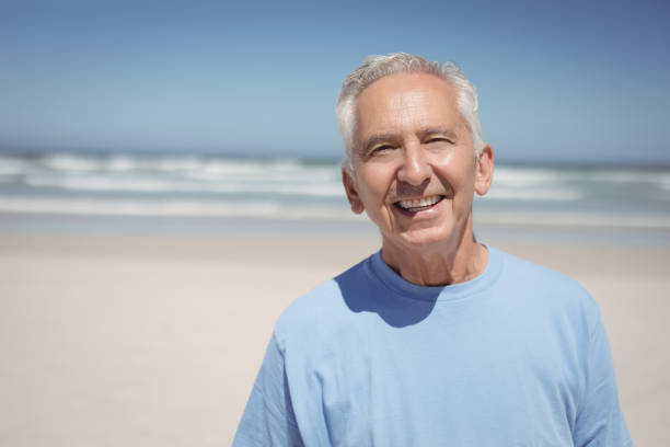 istock Portrait of smiling senior man at beach 828720716