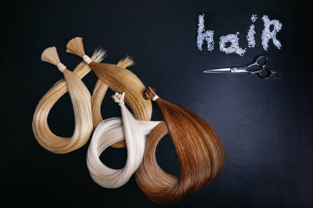 extensiones del pelo de cuatro colores sobre un fondo oscuro con unas tijeras. copyspace. vista superior - hair clip fotos fotografías e imágenes de stock
