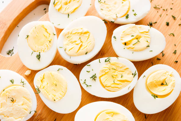 istock Cut boiled eggs with dill on a cutting board close-up 828727568