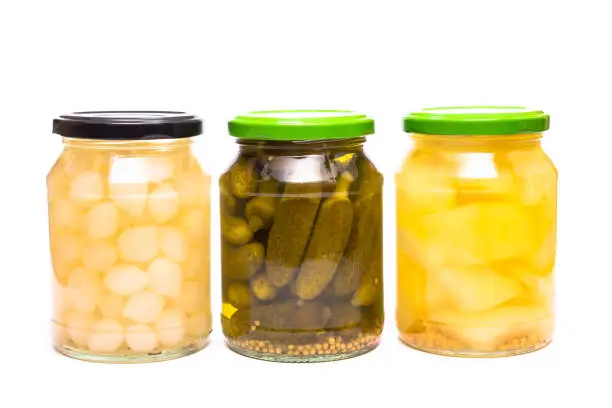 Sour pickled gherking, mustard gherkin and pearl onions in a glass