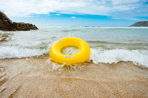 istock Yellow inflatable ring riding a wave at Pend Vounder Beach 828741972