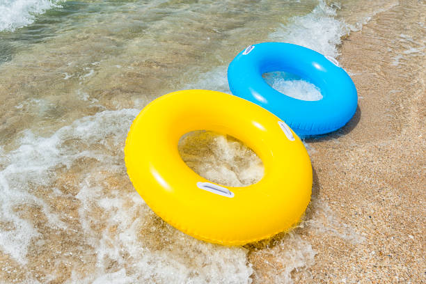 istock Yellow and blue rubber ring floating on incoming wave 828743300