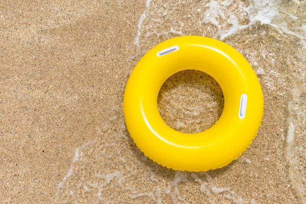 istock Inflated Yellow rubber ring on sand from above. 828743766