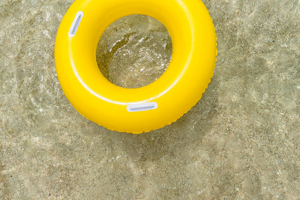 istock Inflated Yellow rubber ring floating on clear sea. 828744010