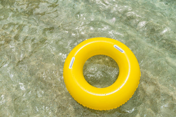istock Inflated Yellow rubber ring floating on clear sea. 828744096