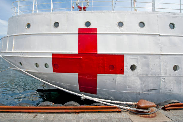 Hospital ship and quayside, Stavanger, Norway. An old historic hospital ship lies alongside the quayside, notable for its buckled hull plates and freshly repainted red cross, Stavanger, Norway