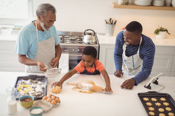 istock Boy preparing cookie dough with his father and grandfather in kitchen 828761914