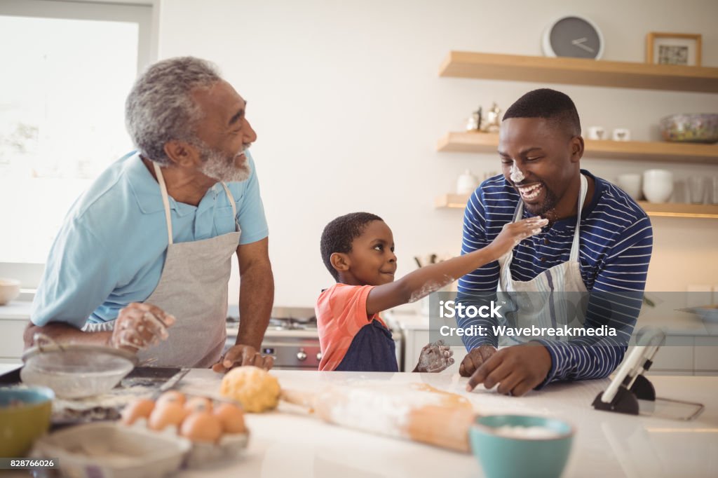 Família de várias gerações com farinha no pé do nariz na cozinha - Foto de stock de Família de várias gerações royalty-free