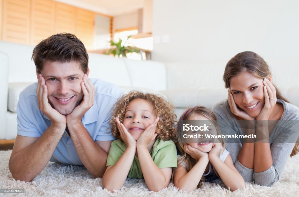 Family lying on a carpet Family lying on a carpet in their living room 20-29 Years Stock Photo