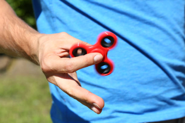 istock Happy man holds spinner antistress toy in hand 828773710