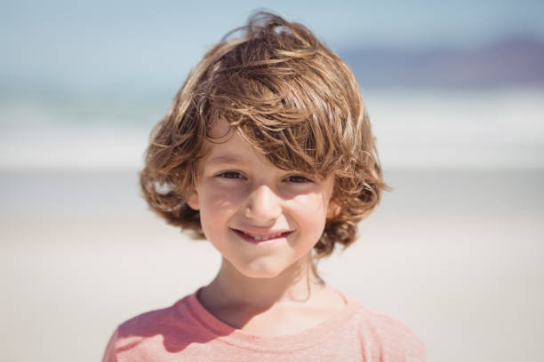 istock Portrait of smiling boy at beach 828779664