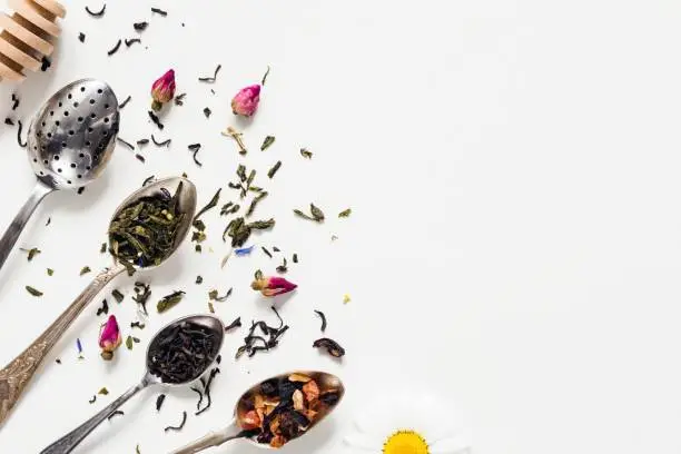 Photo of Dried tea leaf in tea spoons on white background