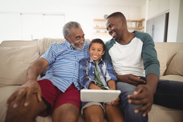 istock Multi-generation family using digital tablet in living room 828781212
