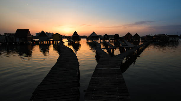 istock Floating village over the lake. Sunset landscape. 828797780