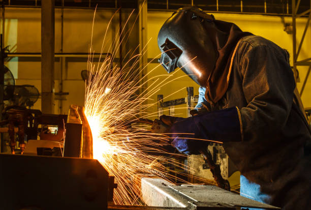 welder, welding automotive part in a car factory - employment issues flash imagens e fotografias de stock