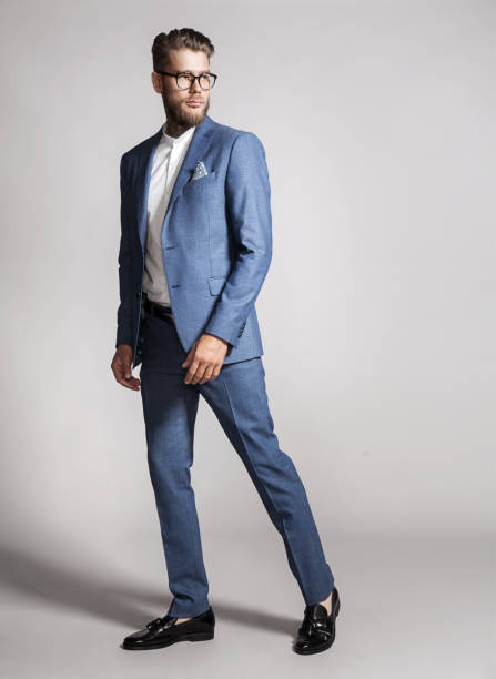 istock Bearded  handsome man in a suit on a gray background 828820372