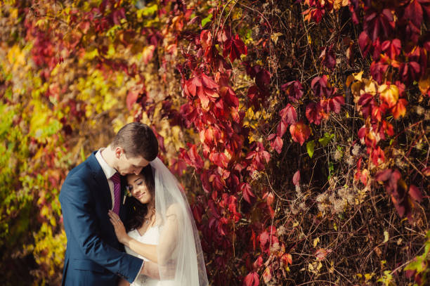 istock Beautiful wedding couple on a walk in autumn park 828845896