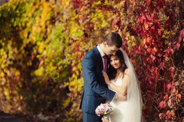 istock Beautiful wedding couple on a walk in autumn park 828846022