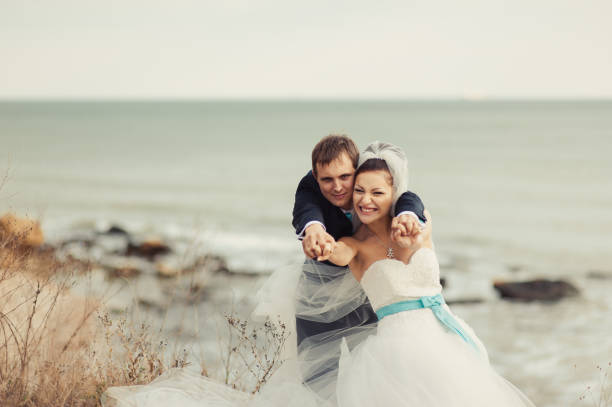 istock Wedding couple on a walk by the sea 828860108