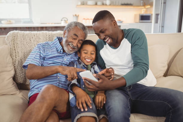 istock Smiling multi-generation family using mobile phone in living room 828865674