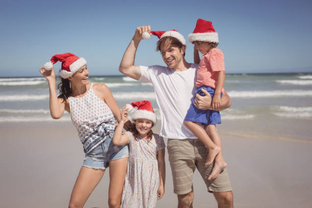 istock Smiling family wearing Santa hat at beach 828869650