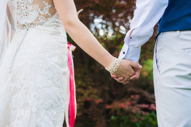 istock Bride and groom holding hands, close-up. 828870388