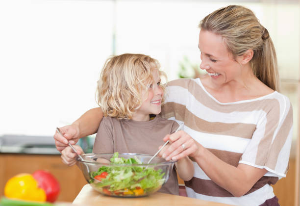 istock Happy mother and son preparing salad 828871792
