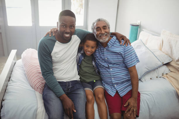 istock Smiling multi-generation family sitting together on bed 828872484
