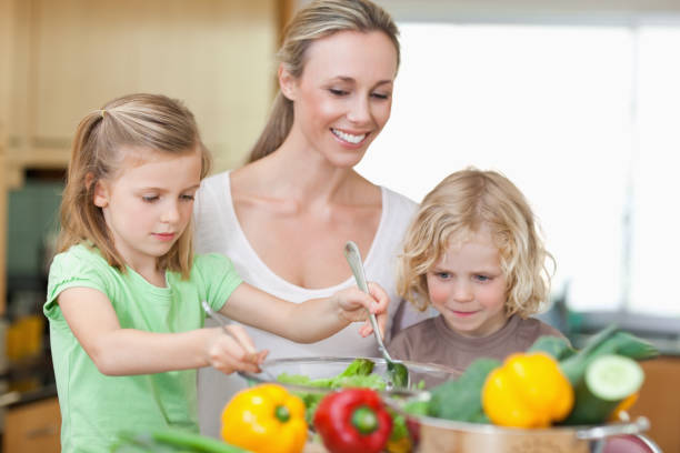 istock Mother with daughter and son preparing salad 828874734