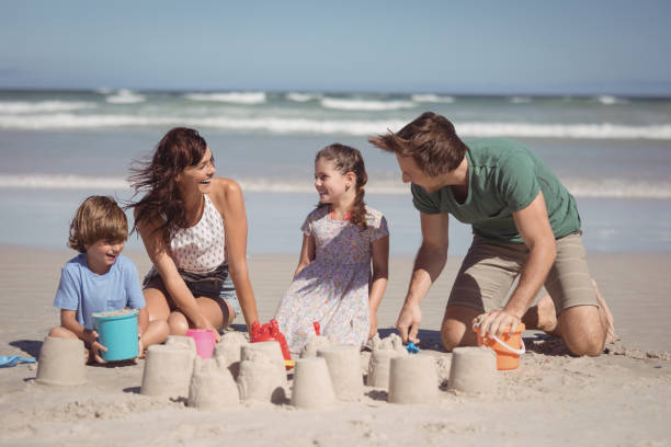 istock Cheerful family making sand castle at beach 828874988