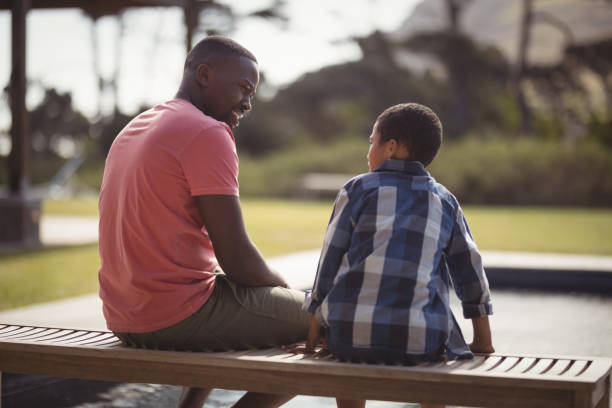 Father talking to son near pool side