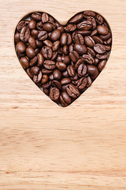 istock Heart shaped coffee beans on wooden board 828905898